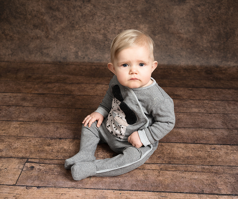 Baby boy wearing a grey sleep suit taken by Alice James Photography, newborn photographer Hitchin
