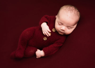 Baby boy in a red outfit taken by Alice James Photography