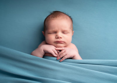Baby boy asleep on a blue blanket taken at a newborn photoshoot, Hitchin