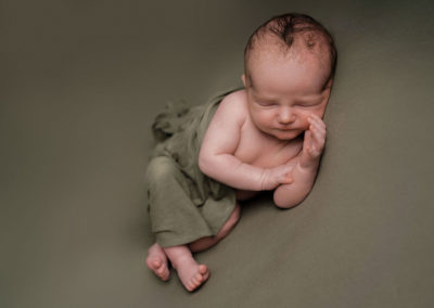 Baby boy asleep on a green blanket taken by Alice James Photography, newborn photographer Hertfordshire