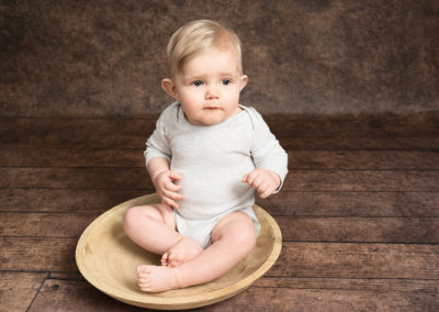 Baby boy sat in a wooden bowl taken by Alice James Photography, baby photographer Hitchin