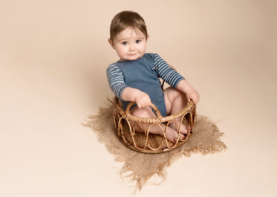 Baby boy sat in a wicker basket. Taken by Alice James Photography, Baby photographer Hitchin