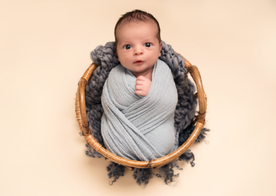 Baby boy in a basket taken by Alice James Photography, newborn photographer Hertfordshire