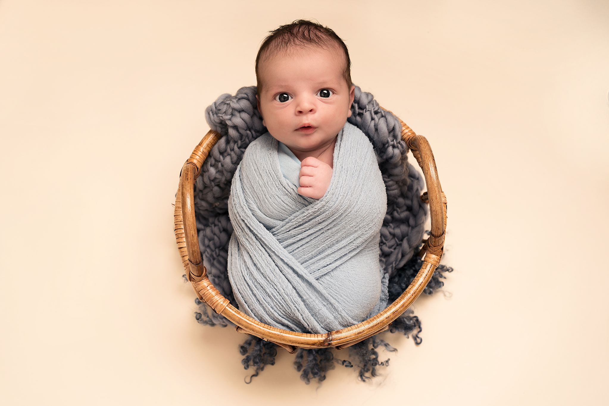 Baby boy in a basket taken by Alice James Photography in a newborn photoshoot, Hitchin