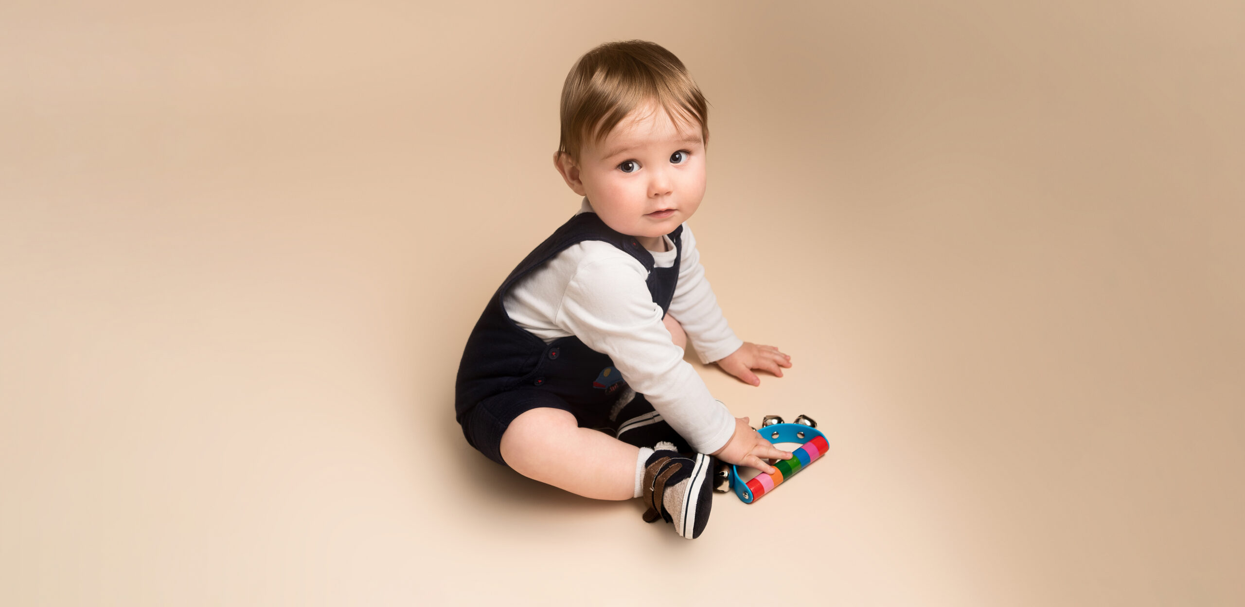 Baby boy playing with a rattle bell taken by Alice James Photography - baby photographer Letchworth