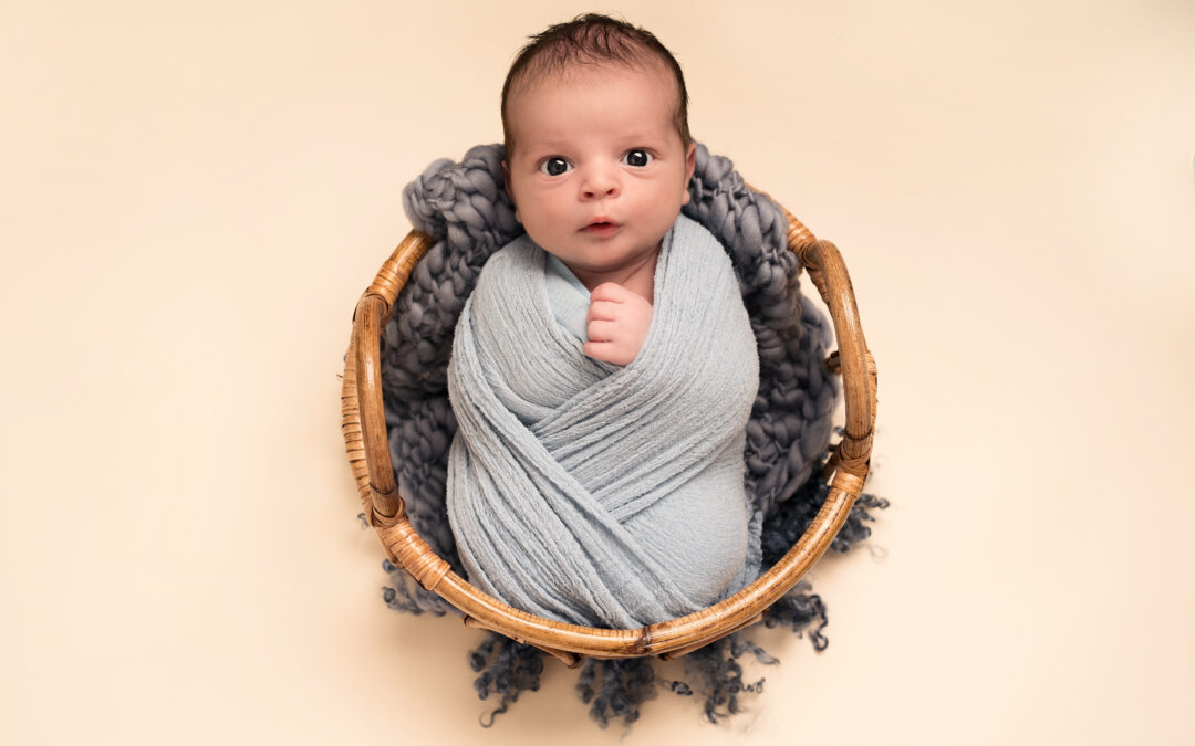 Image of baby boy in basket used on blog post detailing the best baby apps.