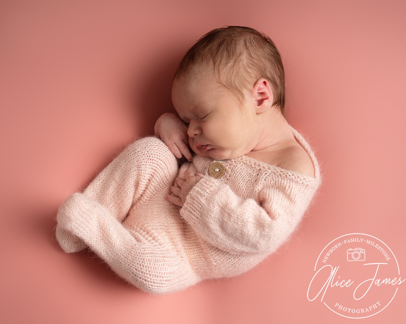 Baby girl asleep on a pink blanket, wearing. pink knitted outfit taken at a newborn photoshoot Hitchin by Alice James Photography